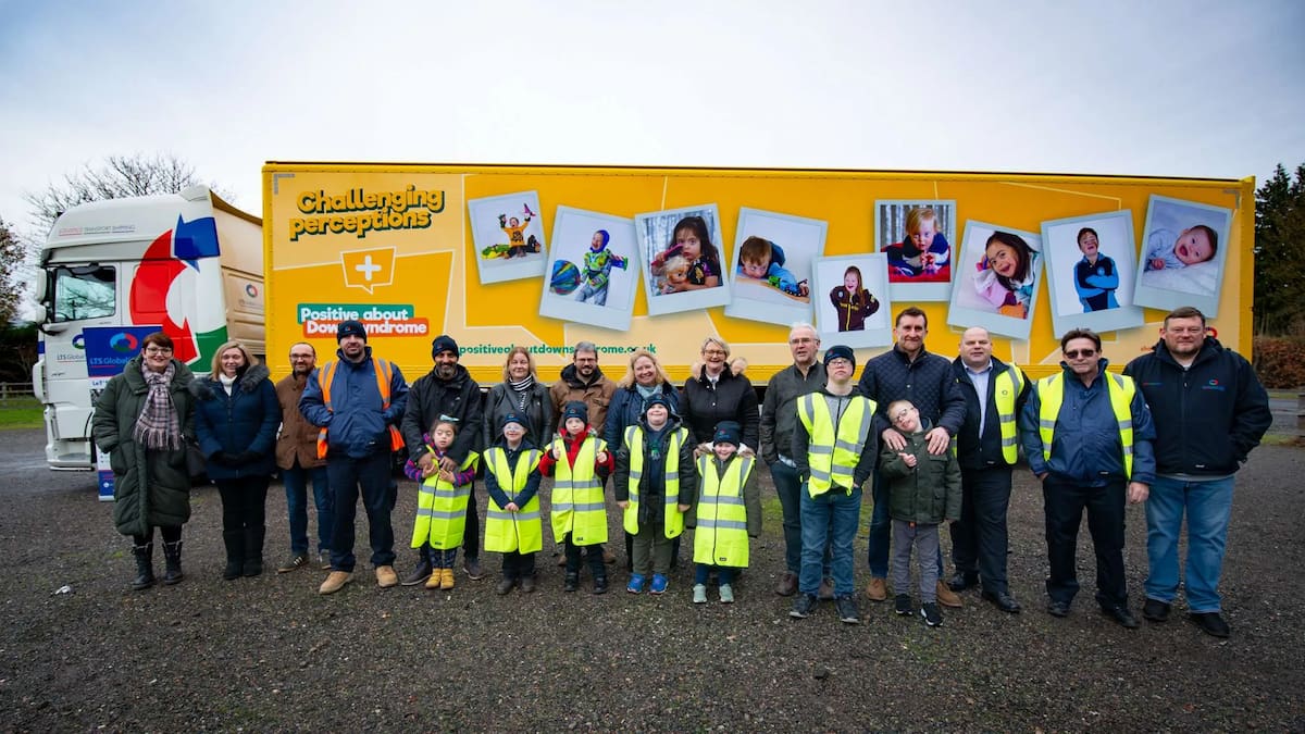 A group of adults and children stood in front of LTS truck supporting Challenging Perceptions