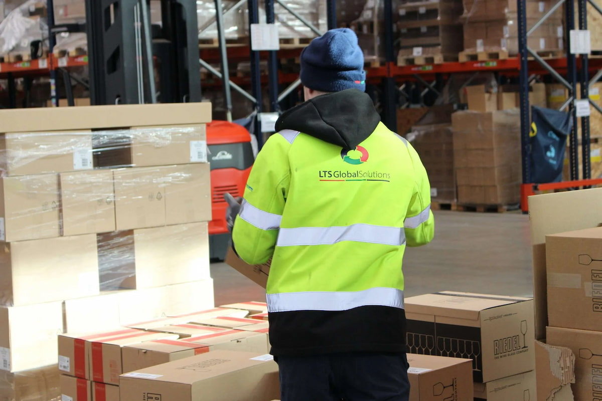 An LTS employee in hi-vis, walking into a warehouse