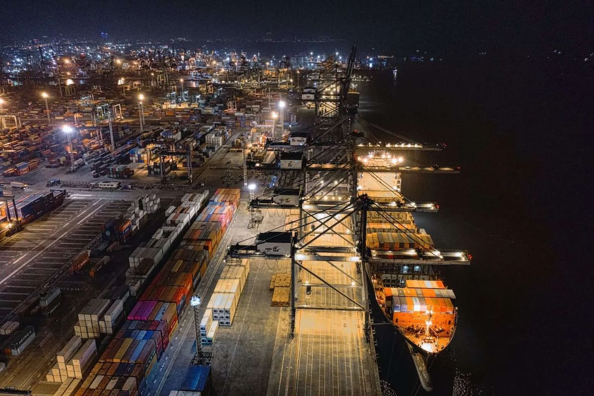 A cargo ship next to a port at night